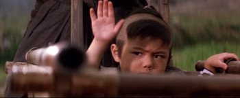 Movie still from “Shogun Assassin” (1980), directed by Kenji Misumi – A young boy with his hand up in the air in front of a window; Close Up shot, High angle