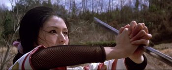 Movie still from “Shogun Assassin” (1980), directed by Kenji Misumi – A woman holding a knife in her mouth; Close Up shot, Low angle