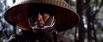 Movie still from “Shogun Assassin” (1980), directed by Kenji Misumi – A man wearing a hat and a mask; Close Up shot, Low angle