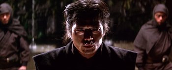 Movie still from “Shogun Assassin” (1980), directed by Kenji Misumi – A person wearing a suit and tie; Close Up shot, Low angle