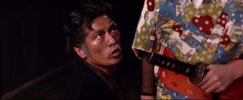 Movie still from “Shogun Assassin” (1980), directed by Kenji Misumi – An older man in a kimono looking at a woman in a kimono; Close Up shot, Over the shoulder angle