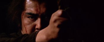 Movie still from “Shogun Assassin” (1980), directed by Kenji Misumi – A man with a knife in his hand; Extreme Close Up shot, Low angle