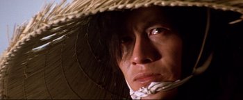 Movie still from “Shogun Assassin” (1980), directed by Kenji Misumi – A person wearing a straw hat; Close Up shot, Low angle