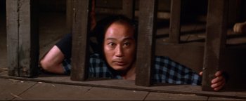 Movie still from “Shogun Assassin” (1980), directed by Kenji Misumi – A man is looking through the bars of a window; Close Up shot, High angle
