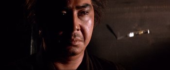 Movie still from “Shogun Assassin” (1980), directed by Kenji Misumi – A man's face in the dark; Close Up shot, Low angle