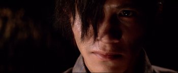 Movie still from “Shogun Assassin” (1980), directed by Kenji Misumi – A person's face with a dark background; Extreme Close Up shot, Low angle