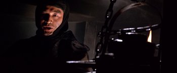 Movie still from “Shogun Assassin” (1980), directed by Kenji Misumi – A man wearing a black hood is looking at the camera; Close Up shot, Low angle