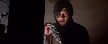 Movie still from “Shogun Assassin” (1980), directed by Kenji Misumi – A man holding a pair of blue and white umbrellas; Close Up shot, Low angle