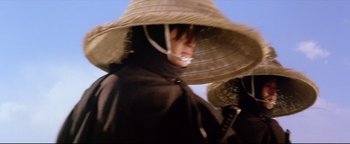 Movie still from “Shogun Assassin” (1980), directed by Kenji Misumi – A person wearing a hat and holding a sword; Close Up shot, Low angle