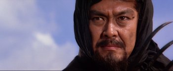 Movie still from “Shogun Assassin” (1980), directed by Kenji Misumi – A person with a beard wearing a hood; Close Up shot, Low angle