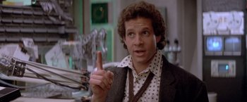 Movie still from “Short Circuit” (1986), directed by John Badham – A man in a polka dot shirt is pointing to the side; Close Up shot, Low angle