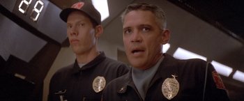 Movie still from “Short Circuit” (1986), directed by John Badham – Two police officers are standing next to each other; Close Up shot, Low angle