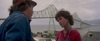 Movie still from “Short Circuit” (1986), directed by John Badham – A woman and a man standing next to each other near a bridge; Close Up shot, Over the shoulder angle
