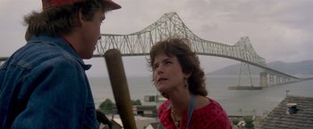 Movie still from “Short Circuit” (1986), directed by John Badham – A woman and a boy are standing in front of a bridge; Close Up shot, Over the shoulder angle