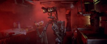 Movie still from “Short Circuit” (1986), directed by John Badham – A robot with lights and a red smoke background; Medium shot, Low angle