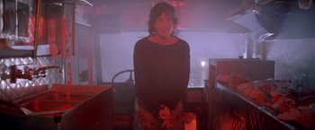 Movie still from “Short Circuit” (1986), directed by John Badham – A woman standing in a room in a dark room; Medium shot, Low angle