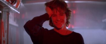 Movie still from “Short Circuit” (1986), directed by John Badham – A woman smiling and touching her hair with a teddy bear; Close Up shot, Low angle