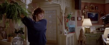 Movie still from “Short Circuit” (1986), directed by John Badham – A woman standing in front of a parrot on a perch; Medium shot, Low angle