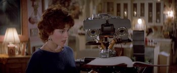 Movie still from “Short Circuit” (1986), directed by John Badham – A woman sitting in front of a robot; Close Up shot, Over the shoulder angle