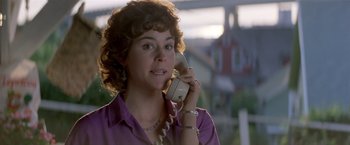 Movie still from “Short Circuit” (1986), directed by John Badham – A woman talking on a phone while wearing a purple shirt; Close Up shot, Low angle
