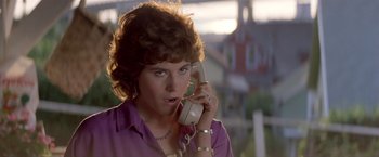 Movie still from “Short Circuit” (1986), directed by John Badham – A woman holding a phone up to her ear; Close Up shot, Low angle