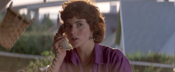 Movie still from “Short Circuit” (1986), directed by John Badham – A woman talking on a phone while wearing a purple shirt; Close Up shot, Low angle