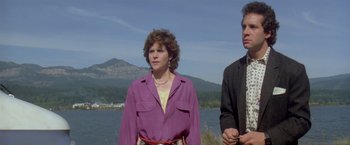 Movie still from “Short Circuit” (1986), directed by John Badham – A woman in a purple shirt standing next to a man in a yellow shirt; Medium shot, Low angle