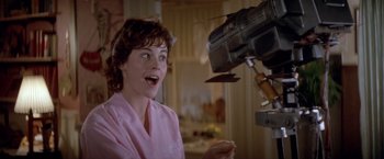 Movie still from “Short Circuit” (1986), directed by John Badham – A woman in a pink bathrobe looking surprised at a camera; Close Up shot, Low angle