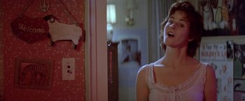 Movie still from “Short Circuit” (1986), directed by John Badham – A woman in a nightgown standing next to a door; Medium shot, Over the shoulder angle