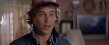 Movie still from “Short Circuit” (1986), directed by John Badham – A person wearing a hat; Close Up shot, Over the shoulder angle