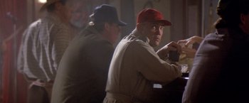 Movie still from “Short Circuit” (1986), directed by John Badham – A man in a red hat and a man in a tan jacket; Medium shot, Low angle