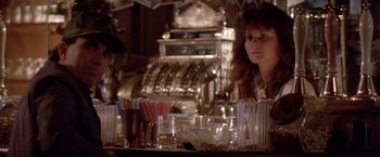 Movie still from “Short Circuit” (1986), directed by John Badham – A woman sitting at a table in front of a cash register; Close Up shot, Low angle