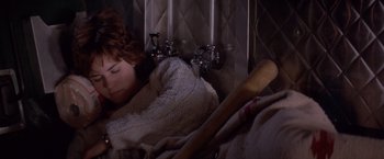 Movie still from “Short Circuit” (1986), directed by John Badham – A woman sleeping with a baseball bat in her hand; Medium shot, Overhead angle