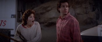 Movie still from “Short Circuit” (1986), directed by John Badham – A woman and a man standing next to each other in front of a wall; Medium shot, Low angle