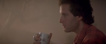 Movie still from “Short Circuit” (1986), directed by John Badham – A person holding a cup of coffee; Close Up shot, Low angle