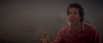 Movie still from “Short Circuit” (1986), directed by John Badham – A man in a red shirt is talking to someone; Medium shot, Low angle