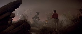 Movie still from “Short Circuit” (1986), directed by John Badham – A man standing next to a tree in the dark; Wide shot, Low angle