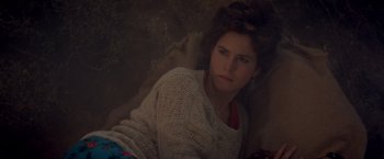 Movie still from “Short Circuit” (1986), directed by John Badham – A woman in a white sweater sitting on a couch; Close Up shot, High angle