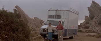 Movie still from “Short Circuit” (1986), directed by John Badham – A man and a woman standing in front of an rv; Wide shot, Low angle
