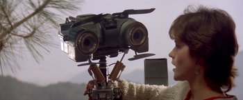 Movie still from “Short Circuit” (1986), directed by John Badham – A person is holding a video camera up to the camera; Close Up shot, Low angle