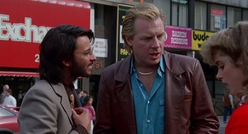 Two men standing next to each other on the sidewalk