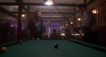 Movie still from “Short Circuit 2” (1988), directed by Kenneth Johnson – A man standing in front of a pool table; Medium shot, Over the shoulder angle