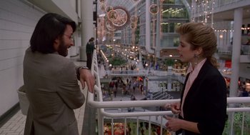 Movie still from “Short Circuit 2” (1988), directed by Kenneth Johnson – A man and a woman talking in an indoor shopping mall; Wide shot, Over the shoulder angle