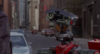 Movie still from “Short Circuit 2” (1988), directed by Kenneth Johnson – An image of a robot that is on the street; Extreme Close Up shot, Low angle