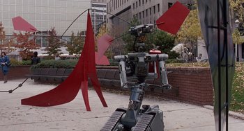 Movie still from “Short Circuit 2” (1988), directed by Kenneth Johnson – A robot is standing in the middle of the street; Wide shot, Low angle