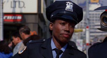 Movie still from “Short Circuit 2” (1988), directed by Kenneth Johnson – A woman in a police officer's uniform; Close Up shot, Low angle