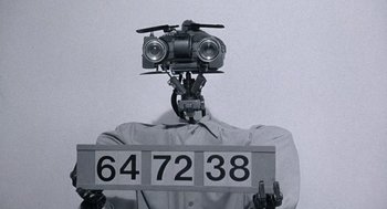 Movie still from “Short Circuit 2” (1988), directed by Kenneth Johnson – A person holding a sign with numbers on it; Extreme Close Up shot, Low angle