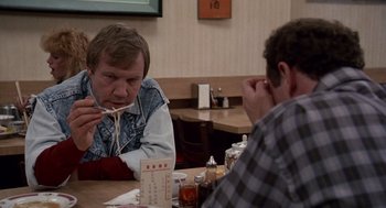 Movie still from “Short Circuit 2” (1988), directed by Kenneth Johnson – Two men are sitting at a table eating noodles; Close Up shot, Over the shoulder angle