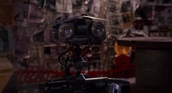 Movie still from “Short Circuit 2” (1988), directed by Kenneth Johnson – A camera with two cameras on top of a tripod; Extreme Close Up shot, Low angle