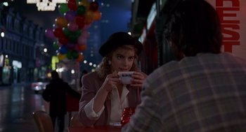 Movie still from “Short Circuit 2” (1988), directed by Kenneth Johnson – A woman sitting at a table holding a cup in front of a man; Medium shot, Over the shoulder angle